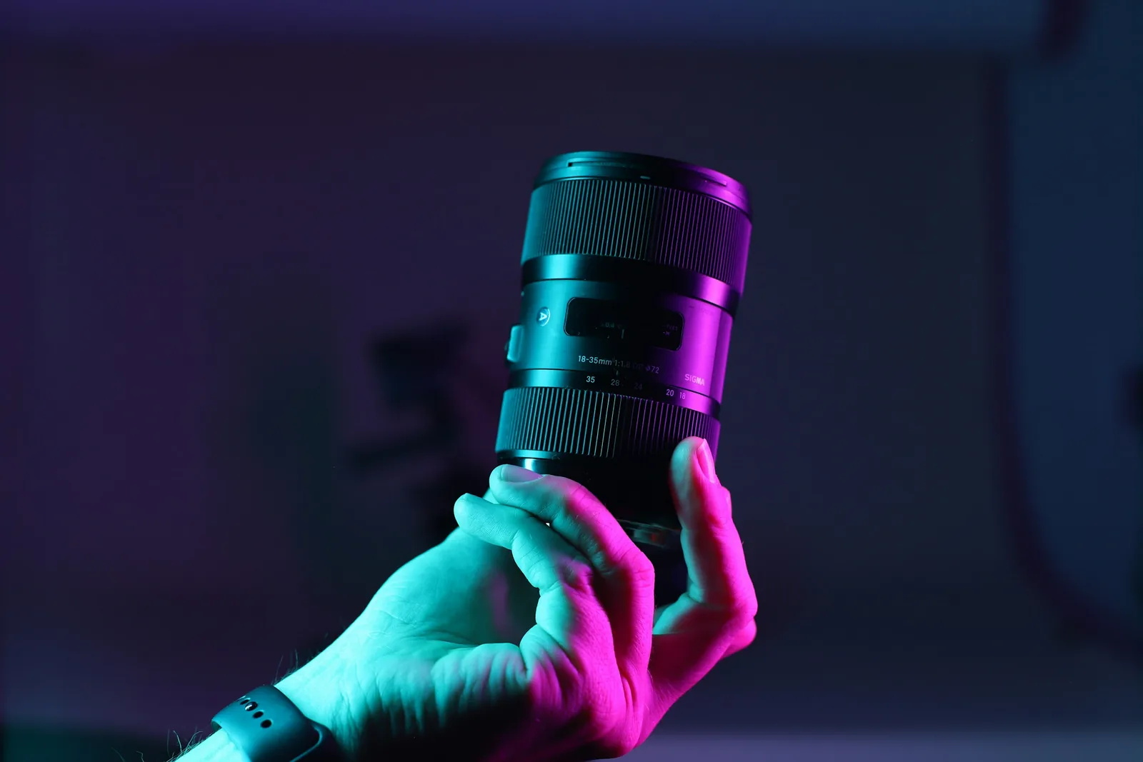 Person Holding Camera Lens: Best Lens for Jewelry Photography